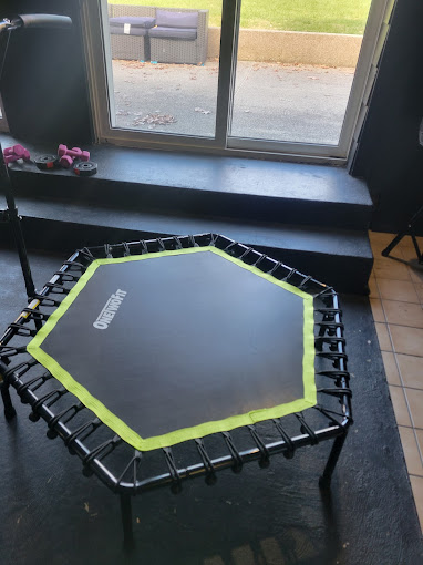 A black and yellow trampoline in front of a window