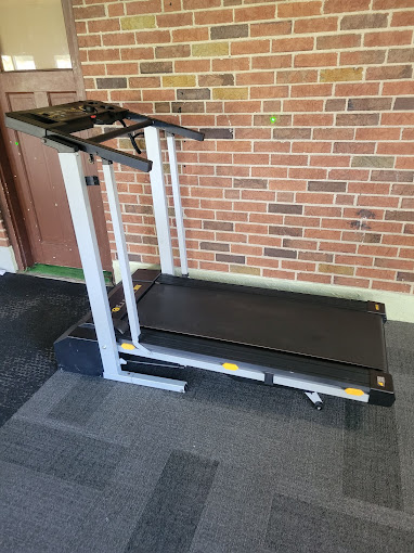 A treadmill in front of a brick wall